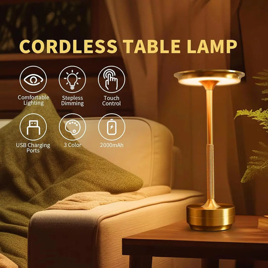 Gold cordless table lamp on a wooden side table with a cozy living room background.