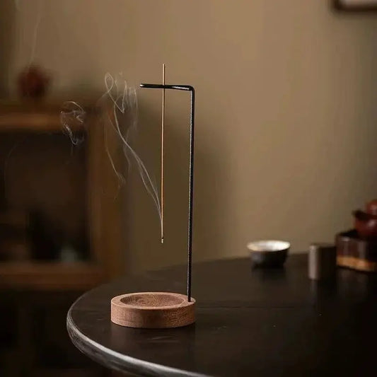 Incense stick holder with incense burning on a dark surface