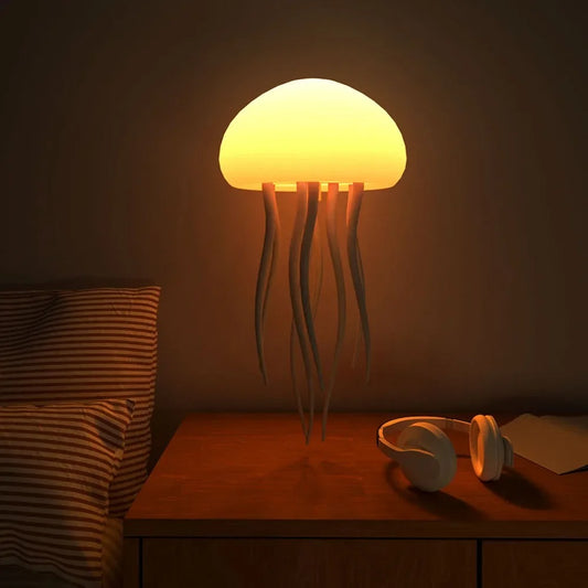 Jellyfish-shaped lamp on a bedside table with a pillow and headphones in a dimly lit room.