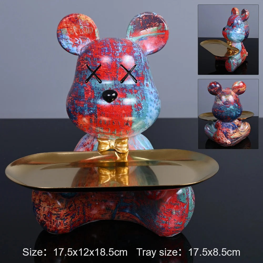 Colorful mouse figurine with a gold base on a dark background