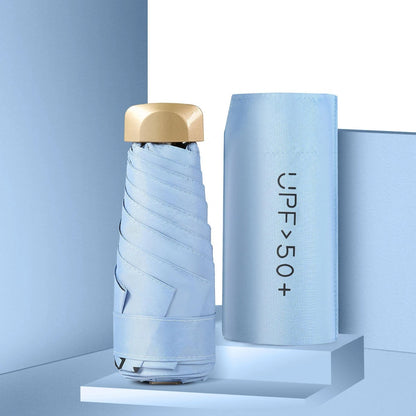 Light blue umbrella with gold top and matching case on a light blue background