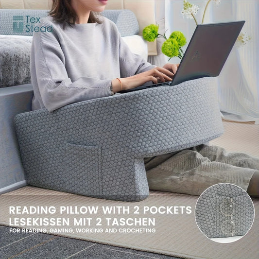 Person using a reading pillow with two pockets in a home setting.
