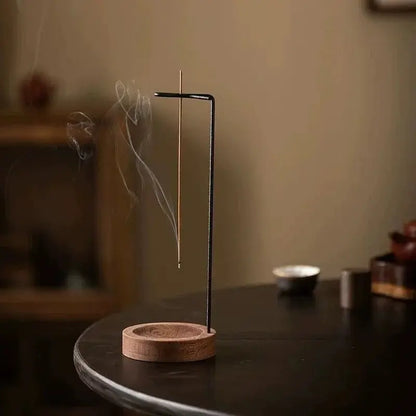 Incense stick holder with incense burning on a dark surface