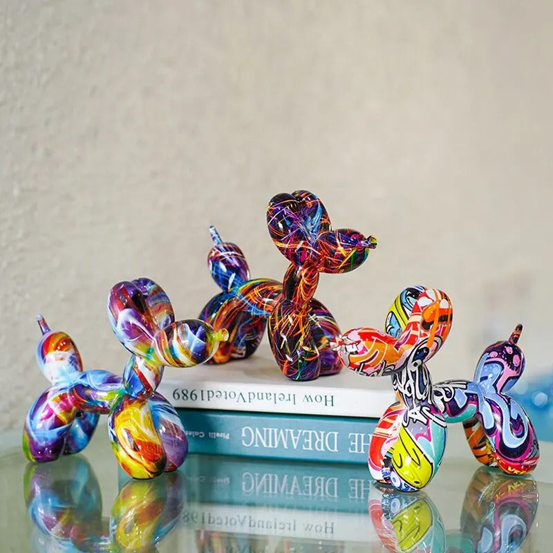 Colorful balloon dog sculptures on a reflective surface with a neutral background