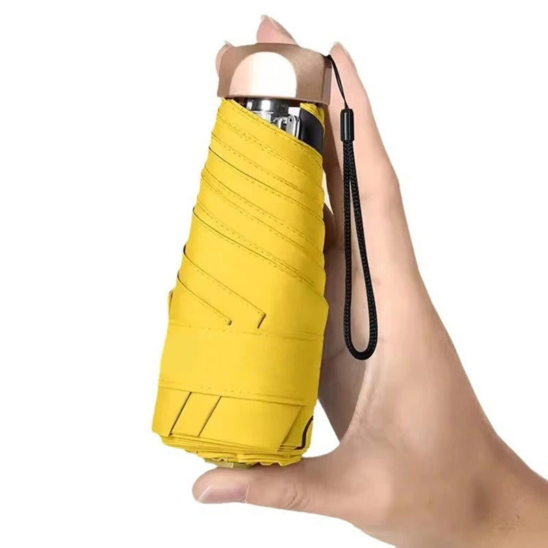 Yellow umbrella held in a hand against a white background