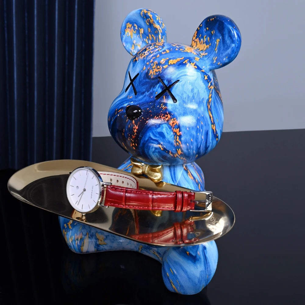 Blue marbled bear figurine with a watch on a dark surface