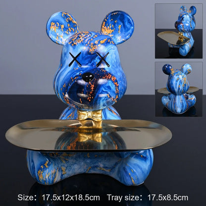 Blue bear figurine with gold accents on a reflective surface